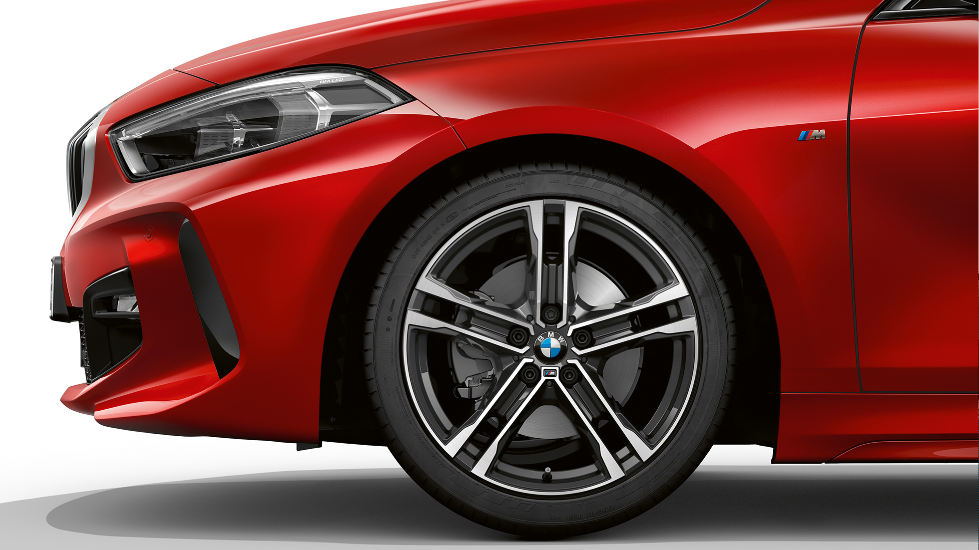 BMW 1 Series Model M Sport, front from the side. BMW 1 Series Model M Sport in Melbourne Red metallic, front from the side with 17" M light-alloy wheel Double-spoke 550 M style in Bicolour.