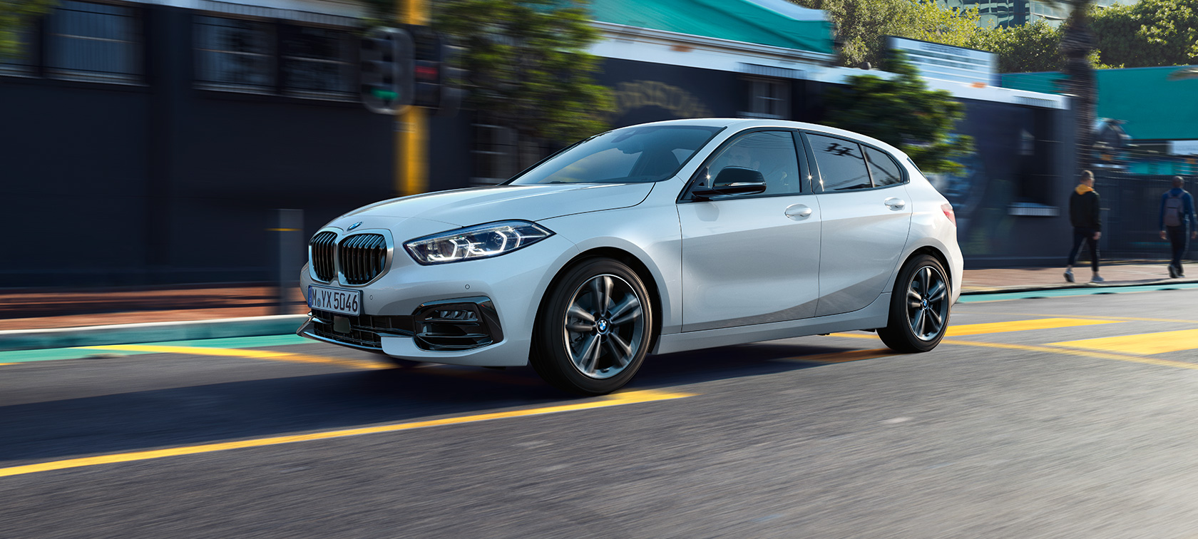 BMW 1 Series Model Sport Line, three-quarter side view. BMW 1 Series Model Sport Line in Mineral White metallic, three-quarter side view, driving.